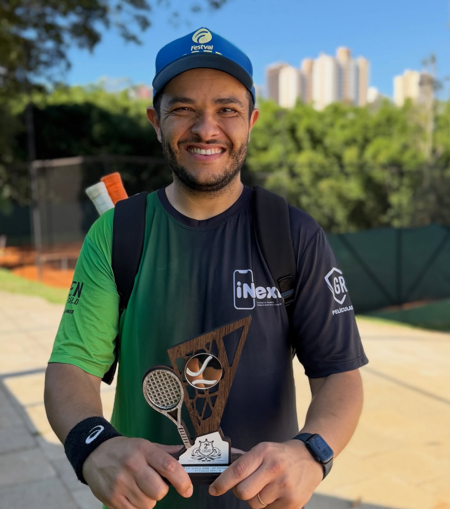 Anderson Felipe sorrindo com um troféu e camiseta da iNext